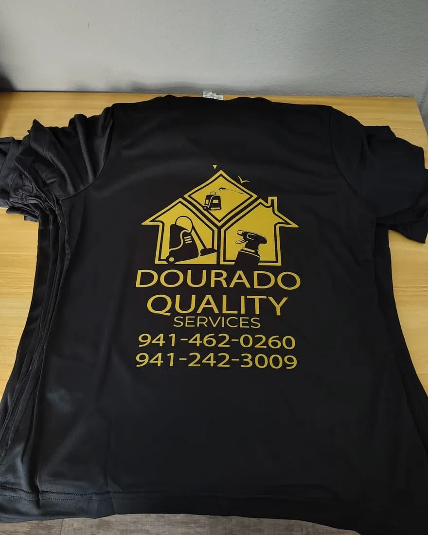 Black tees printed in gold with the Dourado Quality Services logo and phone numbers